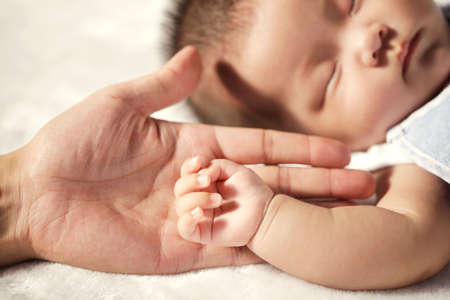 Father holding the hand of the babyの写真素材