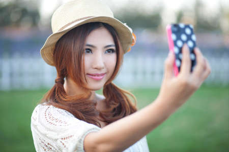 Young fashion female youth with mobile phone self-timerの写真素材
