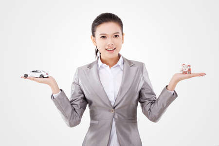 Oriental business woman and car and house model on handの写真素材