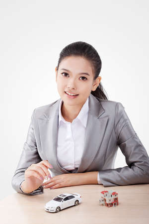 Oriental business woman with car and house modelの写真素材