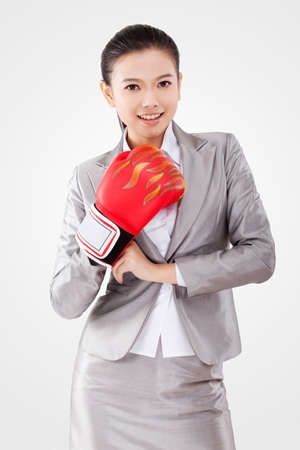 Business woman wearing boxing glovesの写真素材