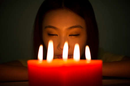 Young woman holding a red candleの写真素材