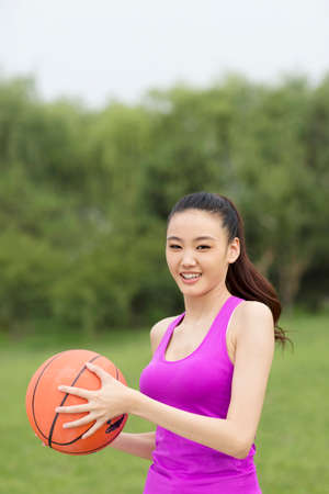 Young woman holding a basketballの写真素材