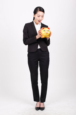 A business woman carrying a piggy bank high quality photoの写真素材