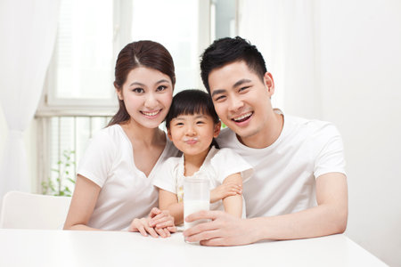 A happy family of three and milk high quality photoの写真素材