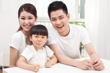 A happy family of three and milk high quality photoの写真素材