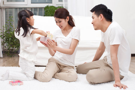 A happy family of three is playing in the living room high quality photoの写真素材