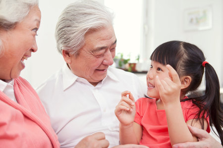 Happy grandparents and grandchildren are playing in the living room high quality photo