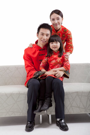 Portrait of family,daughter sitting on fathers leg,mother standing behind,in Tang suitsの写真素材