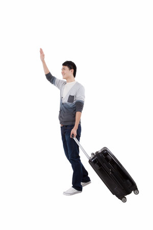 Portrait of young bisiness man pulling valise high quality photoの写真素材