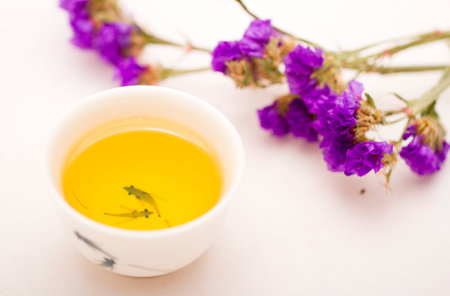 A cup of chinese tea with a bunch of purple flower high quality photo