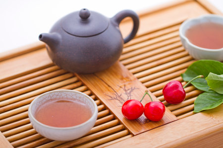 Cherry,teapot,teacup and leaves on tray high quality photoの写真素材