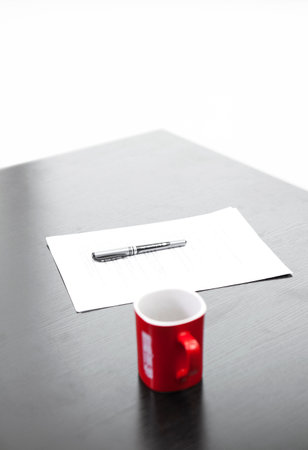 Red coffee cup, pen and paper on the desk high quality photo