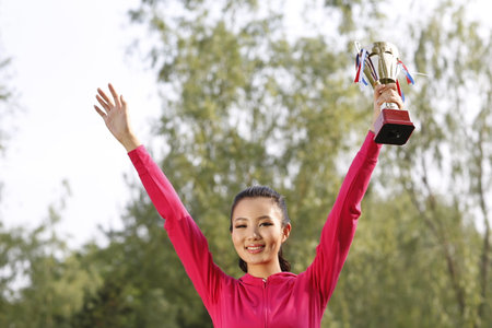 Young woman holding a trophy high quality photoの写真素材