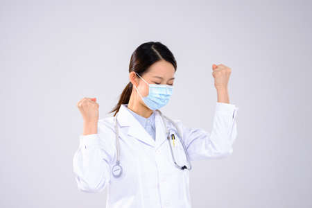 A young woman doctor with a mask boomed with fistの写真素材