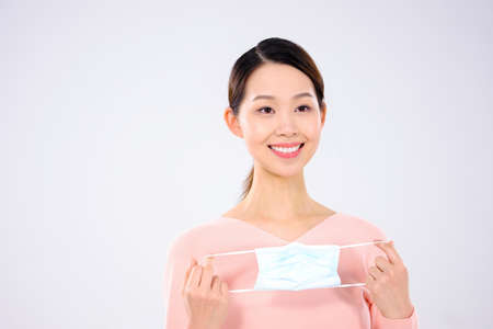 A young woman took off her mask smilingの写真素材