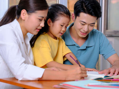 Young parents help their children with their homework high quality photoの写真素材
