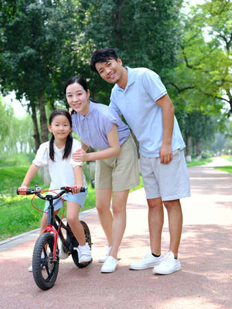 Parents teach their children to ride bicycles high quality photoの写真素材