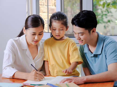 Young parents help their children with their homework high quality photoの写真素材