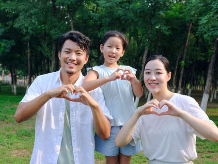 Happy family of three playing in the park high quality photoの写真素材