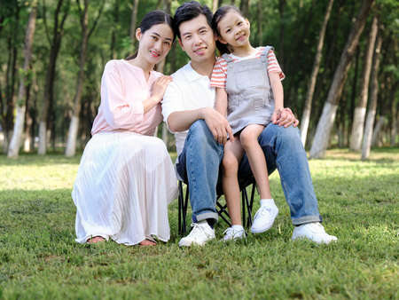 Happy family of three playing in the park high quality photoの写真素材