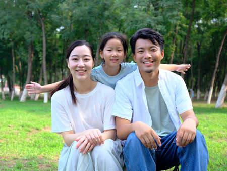 Happy family of three playing in the park high quality photoの写真素材
