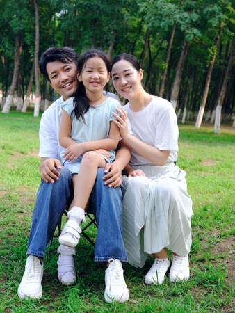Happy family of three playing in the park high quality photo