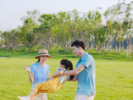 Happy family of three playing in the park high quality photoの写真素材