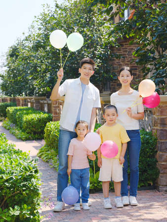 Happy family of four in the outdoor group photo high quality photoの写真素材