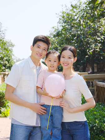 Happy family of three in the outdoor group photo high quality photoの写真素材