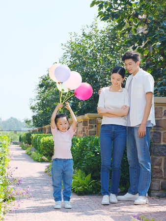 Happy family of three in the outdoor group photo high quality photoの写真素材