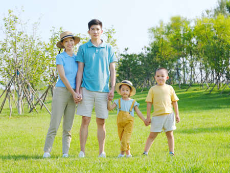 Happy family of four in the outdoor group photo high quality photoの写真素材
