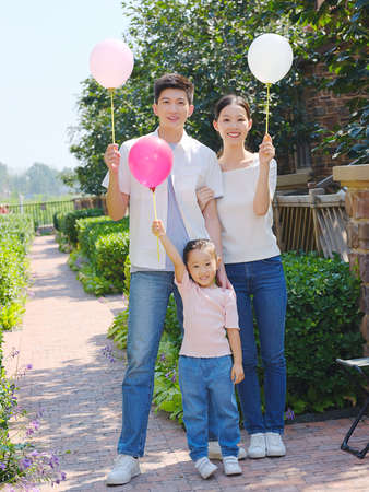 Happy family of three in the outdoor group photo high quality photoの写真素材