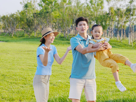 Happy family of three playing in the park high quality photoの写真素材