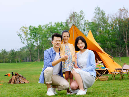 Happy family of three camping outdoors high quality photoの写真素材