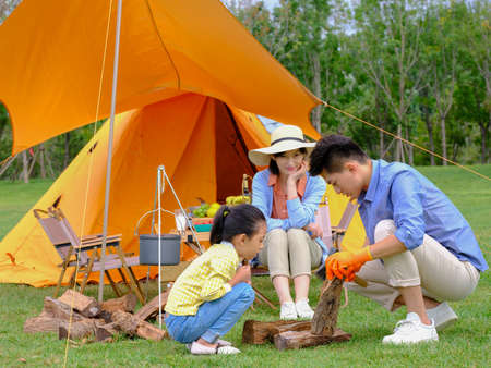 Happy family of three camping outdoors high quality photoの写真素材