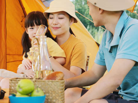 A happy family of three having a picnic outdoors high quality photoの写真素材