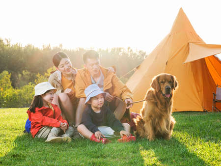 Happy family of four and pet dog in outdoor photo high quality photoの写真素材