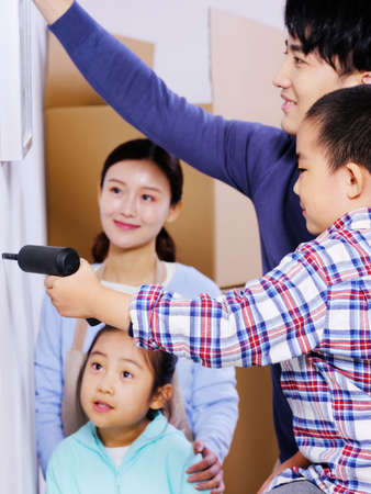 A happy family of four decorates their house high quality photoの写真素材