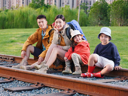 Happy family of four sitting on the track to rest high quality photo