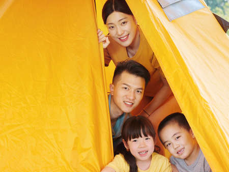 Happy family of four in tent high quality photoの写真素材