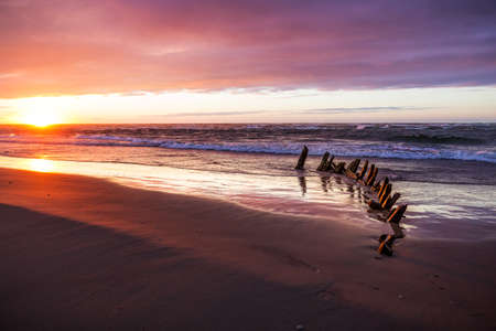 The beach at Hirtshals, Denmark at sunset with an old shipwreckの写真素材