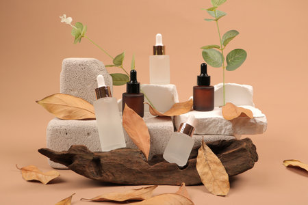 Spa still life with essential oils, stones and leaves on color backgroundの写真素材