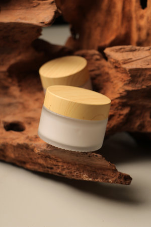 cosmetic cream in a white jar on a wooden background close-upの写真素材