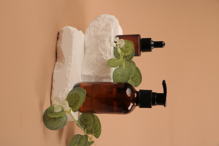 Essential oils in glass bottles and towels on a beige backgroundの写真素材