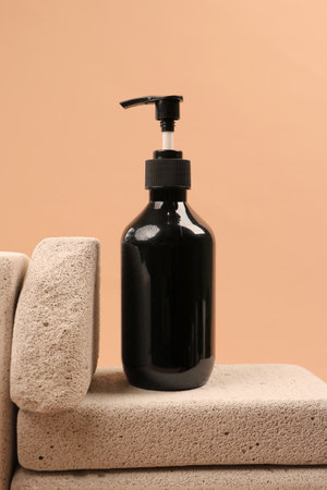 Black bottle with liquid soap on a beige background, close-upの写真素材