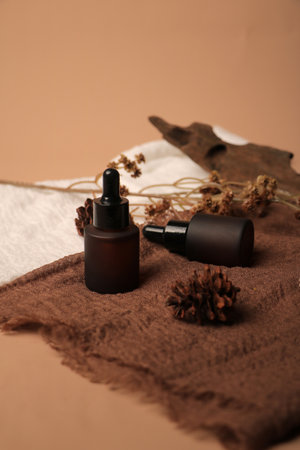 Essential oil in brown glass bottle on brown background, spa conceptの写真素材