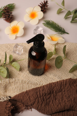 Aromatherapy oil in glass bottle with flower on sackclothの写真素材