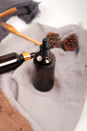 Essential oil in a glass bottle with dropper on a gray background