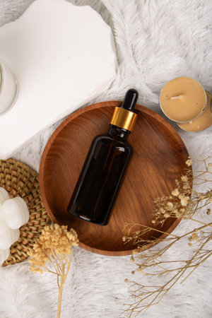 Essential oil in a glass bottle on a wooden plate, spa conceptの写真素材